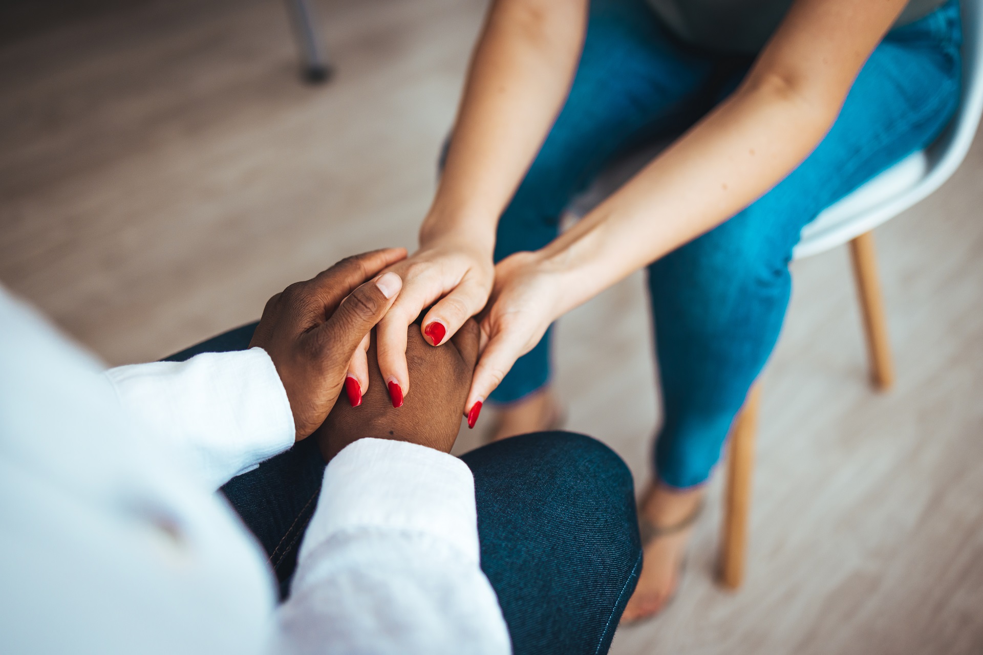 African psychologist hold hands of girl patient, close up. Teenage overcome break up, unrequited love. Abortion decision